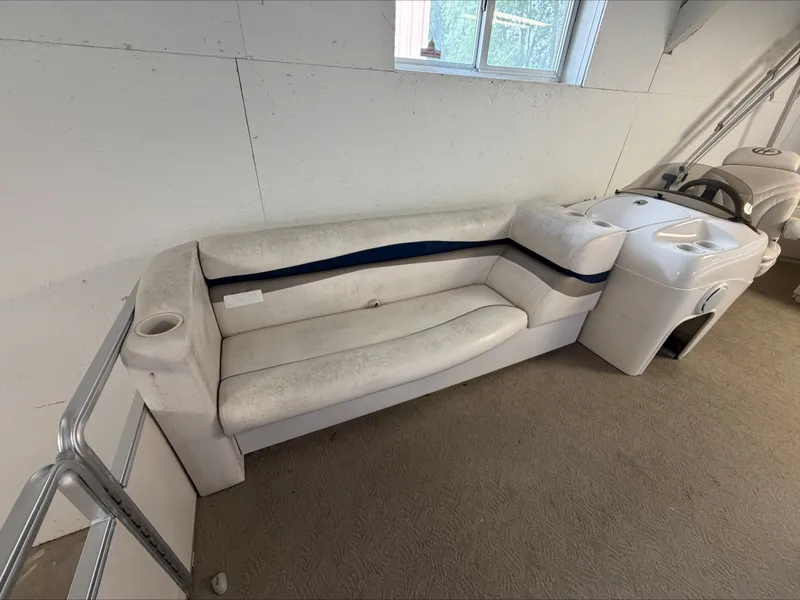 Slide: The Image of A white boat seating sofa with blue trim and built-in cup holder in an indoor setting. - 18