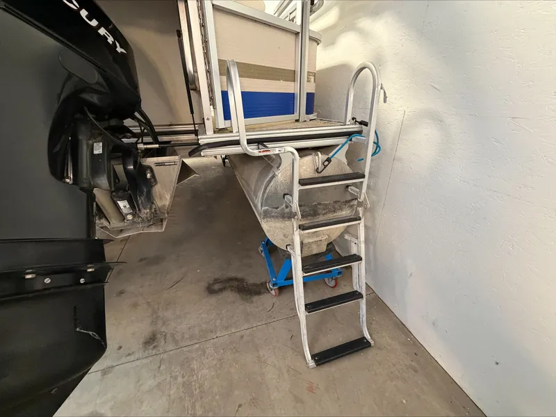Slide: The Image of A 2007 Harris Sunliner 180 with a ladder at the stern, leading into a garage. - 24