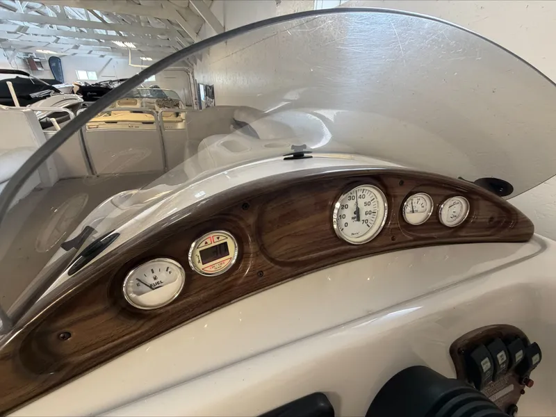 Slide: The Image of The image shows the dashboard of a 2007 Harris Sunliner 180 with wood accents and gauges. - 10