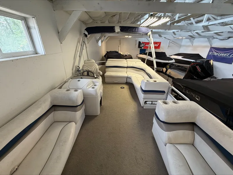 Slide: The Image of The image shows the interior of a 2007 Harris Sunliner 180. It features white cushioned seating and a sink. - 22