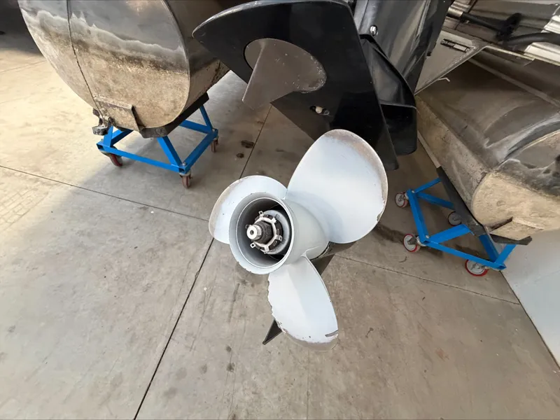 Slide: The Image of A 2007 Harris Sunliner 180 with a propeller on a trailer in a workshop. - 23