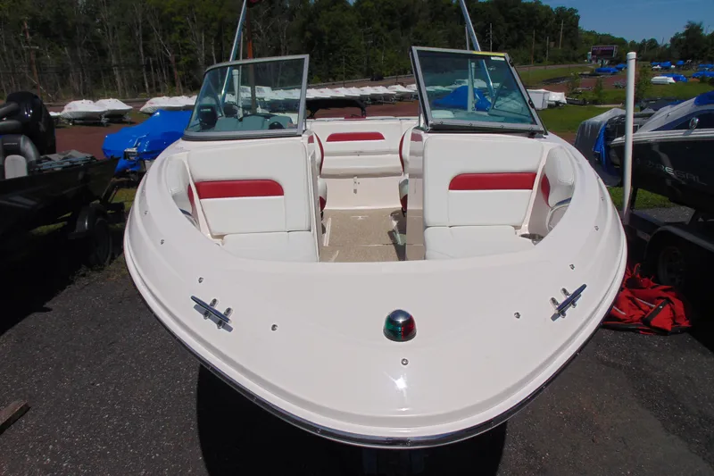 Slide: The Image of 2013 Chaparral 19 Sport H2O boat with white and red interior, docked outdoors. - 2