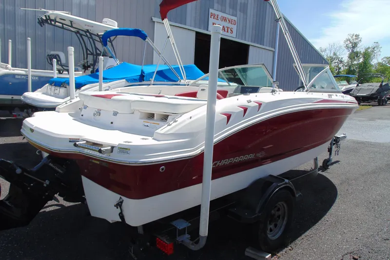 Slide: The Image of 2013 Chaparral 19 Sport H2O boat in a dealership lot, red and white exterior. - 3