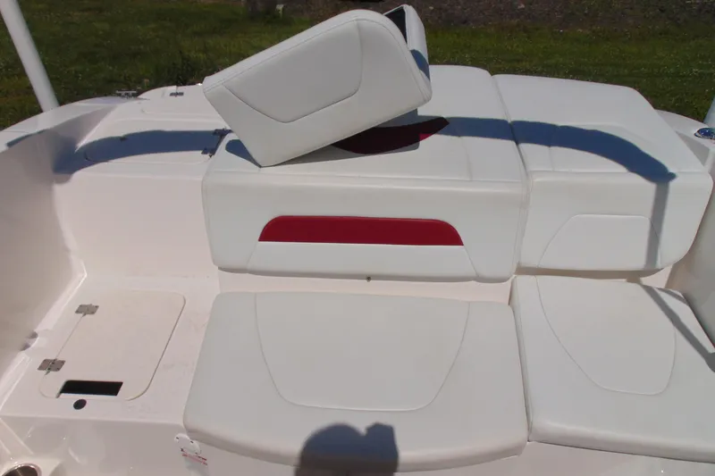 Slide: The Image of 2013 Chaparral 19 Sport H2O boat seating area with white cushions and red accent. - 7