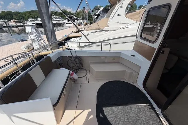 Slide: The Image of 2016 Ranger Tugs R-27 boat deck with seating, docked at marina. - 10