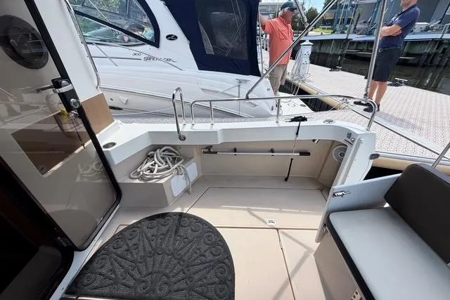Slide: The Image of 2016 Ranger Tugs R-27 boat interior with seating and dock view. - 11