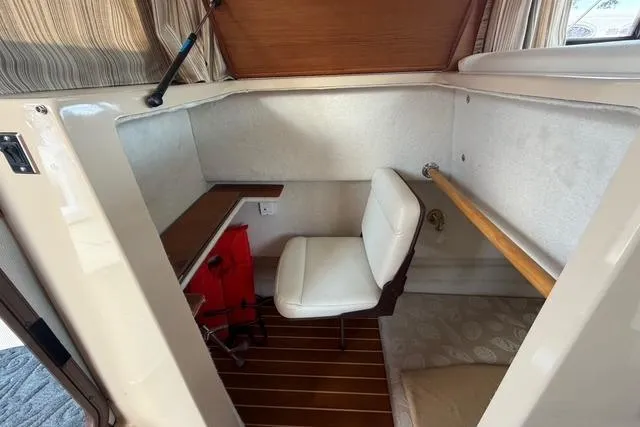 Slide: The Image of 2016 Ranger Tugs R-27 interior cabin with desk, chair, and wooden flooring. - 14