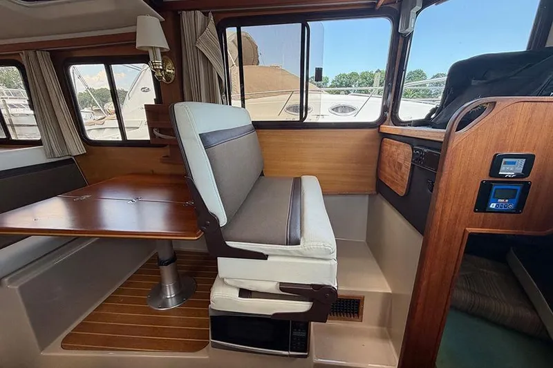Slide: The Image of 2016 Ranger Tugs R-27 interior with seating, table, and control panel. - 17