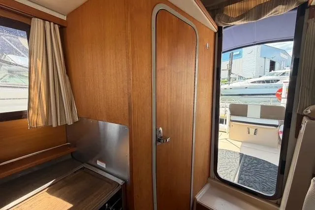 Slide: The Image of Interior view of 2016 Ranger Tugs R-27 boat with wooden paneling and dockside view. - 19