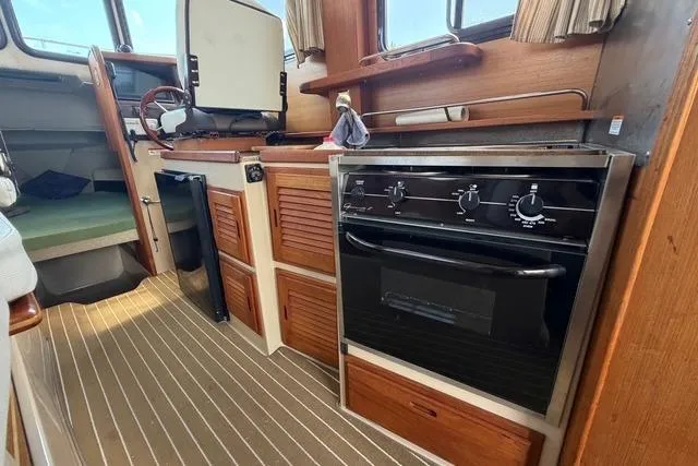 Slide: The Image of Interior of 2016 Ranger Tugs R-27 boat with kitchen and steering area. - 21
