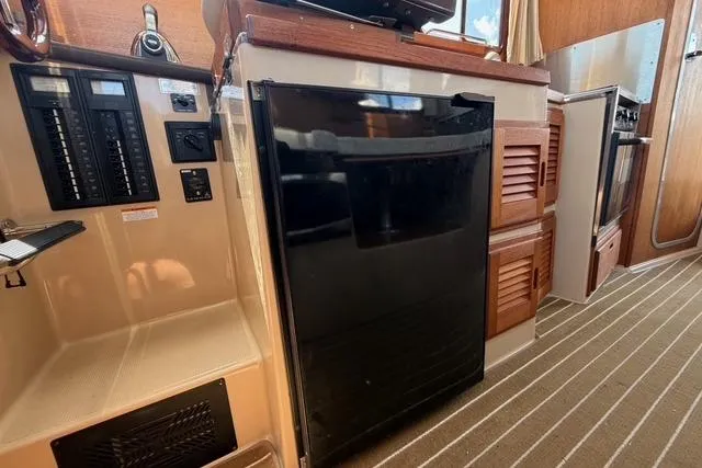 Slide: The Image of Interior of 2016 Ranger Tugs R-27 showing kitchen area with fridge and control panel. - 23