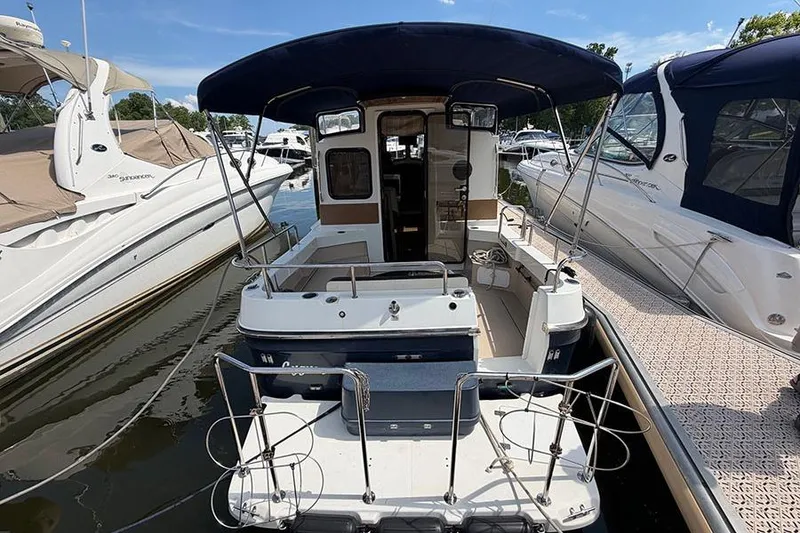 Slide: The Image of 2016 Ranger Tugs R-27 boat docked, featuring spacious deck and canopy. - 7