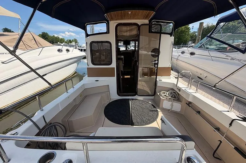 Slide: The Image of 2016 Ranger Tugs R-27 boat interior with seating and canopy at marina. - 8