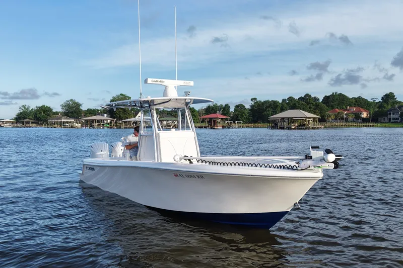 Slide: The Image of 2022 Contender 28 Tournament boat on calm water, surrounded by waterfront homes. - 10