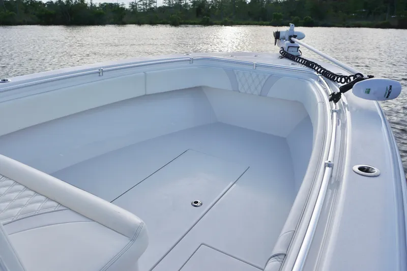 Slide: The Image of 2022 Contender 28 Tournament boat interior with seating and trolling motor on calm water. - 13