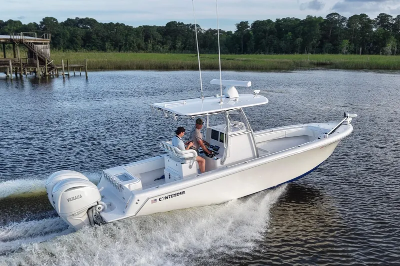 Slide: The Image of 2022 Contender 28 Tournament boat cruising on a scenic river with lush greenery. - 2