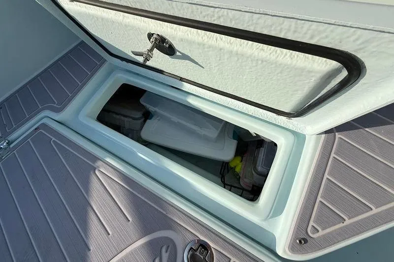 Slide: The Image of Open storage compartment on 2023 Pair Customs 24 Center Console DV boat. - 32
