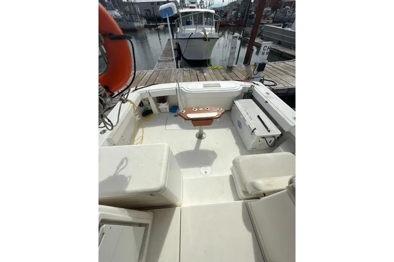 Slide: The Image of 2005 Rampage 33 Express boat interior at dock, featuring seating and fishing equipment. - 8