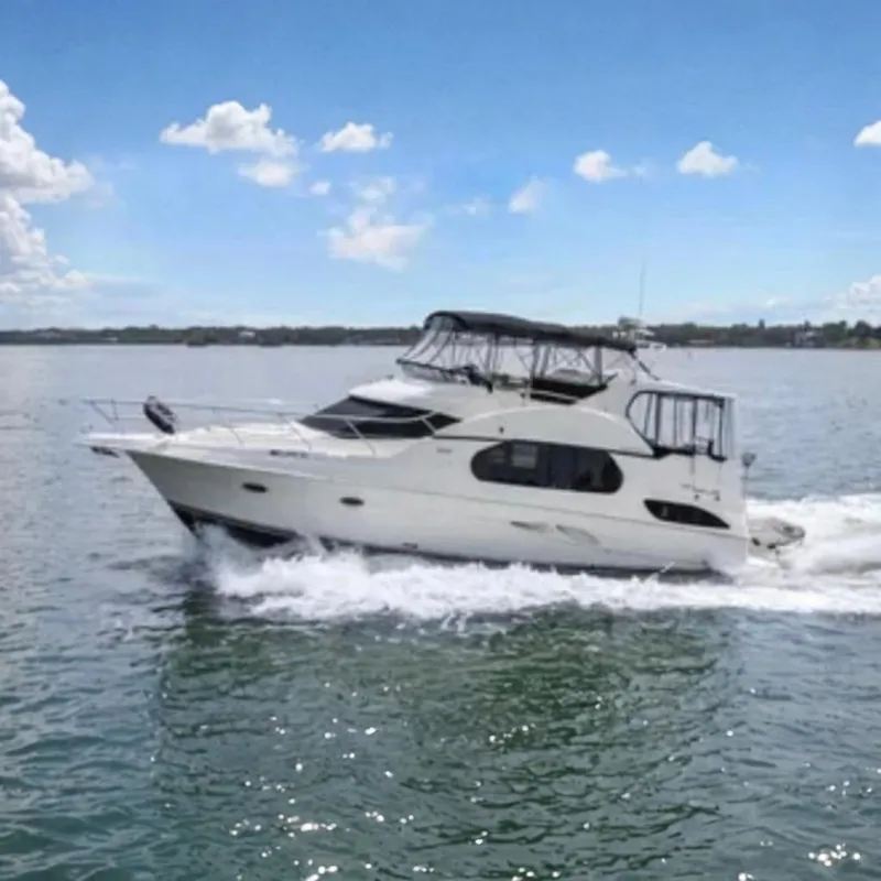 Slide: The Image of 2003 Silverton 43 Motor Yacht cruising on open water under a clear blue sky. - 1
