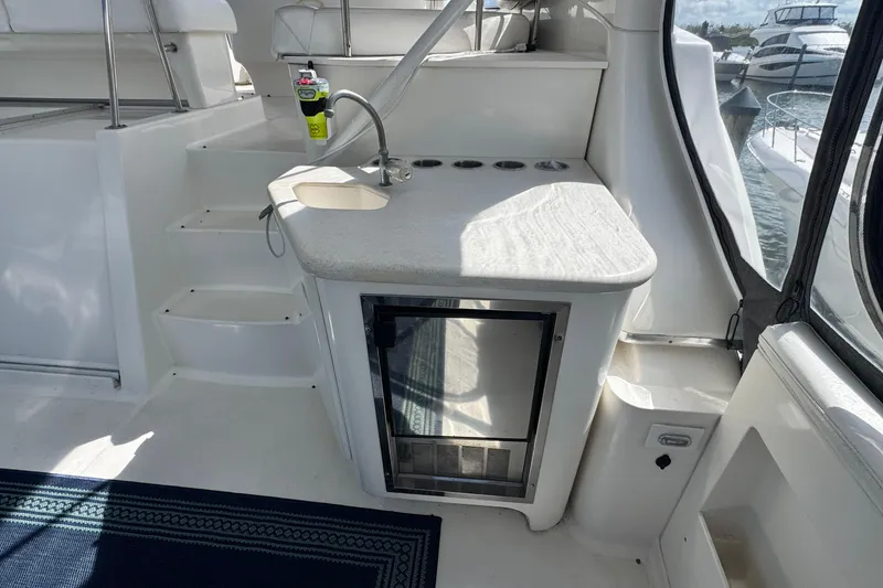 Slide: The Image of 2003 Silverton 43 Motor Yacht interior with kitchenette and steps, docked by water. - 10