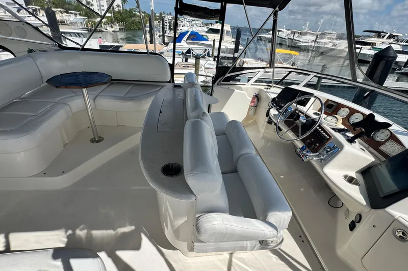 Slide: The Image of 2003 Silverton 43 Motor Yacht interior with helm, seating, and marina view. - 15