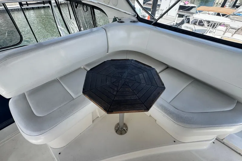 Slide: The Image of Interior of 2003 Silverton 43 Motor Yacht with white seating and wooden table. - 16