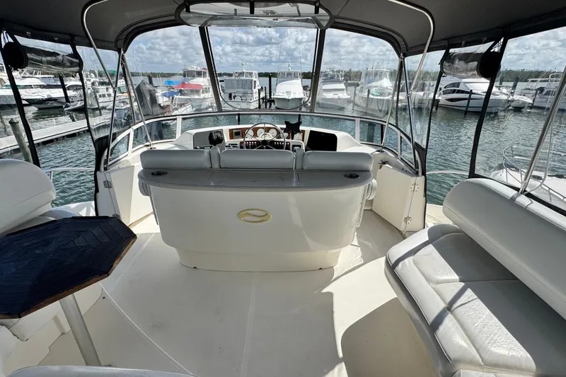 Slide: The Image of 2003 Silverton 43 Motor Yacht interior with helm, seating, and marina view. - 24