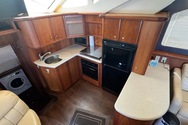 Slide: The Image of Interior of 2003 Silverton 43 Motor Yacht kitchen with wood cabinetry and appliances. - 27
