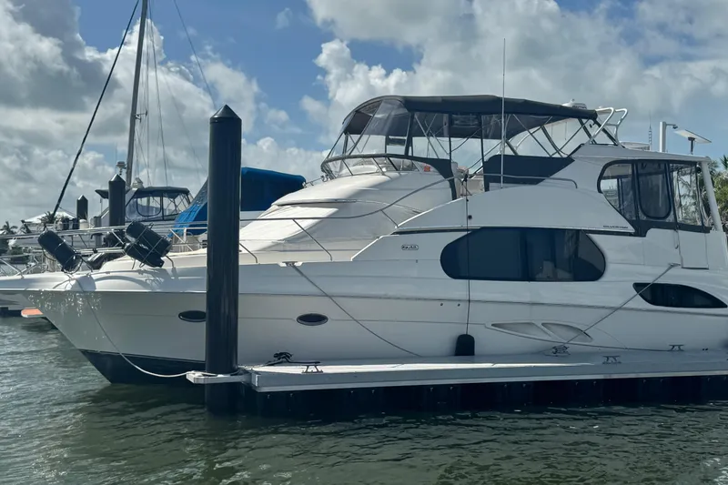 Slide: The Image of 2003 Silverton 43 Motor Yacht docked under a partly cloudy sky. - 3