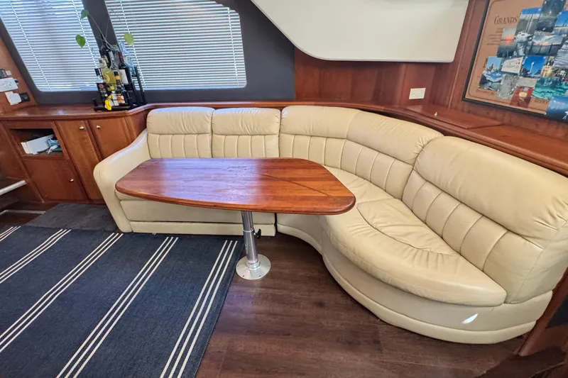 Slide: The Image of Luxurious interior of 2003 Silverton 43 Motor Yacht with leather seating and wooden table. - 30