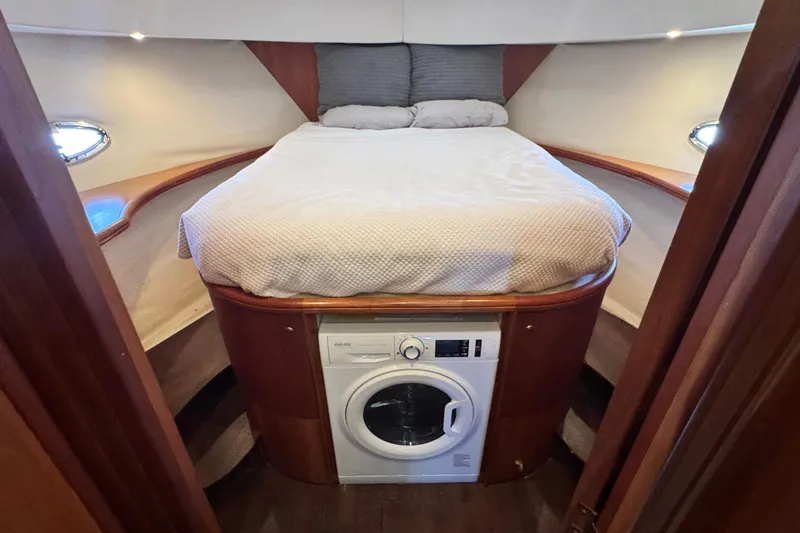 Slide: The Image of 2003 Silverton 43 Motor Yacht bedroom with bed and built-in washer. - 34