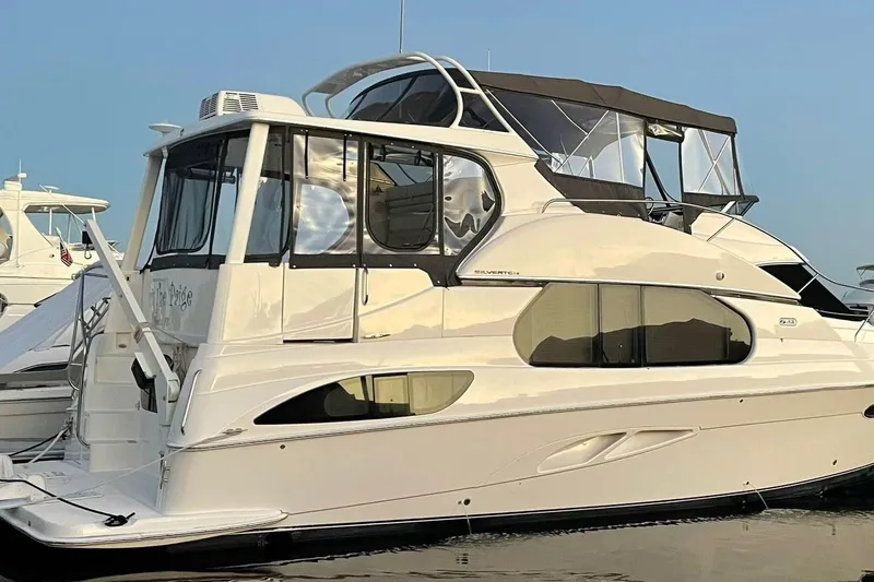 Slide: The Image of 2003 Silverton 43 Motor Yacht docked, featuring sleek design and spacious upper deck. - 4