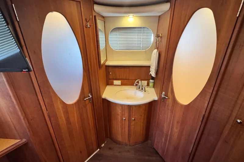 Slide: The Image of Interior of 2003 Silverton 43 Motor Yacht bathroom with wooden cabinetry and sink. - 43