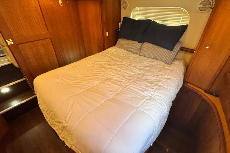 Slide: The Image of Cozy bedroom interior of 2003 Silverton 43 Motor Yacht with wooden accents and comfortable bedding. - 44