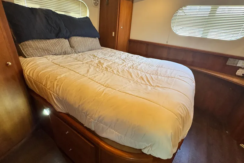 Slide: The Image of Cozy bedroom interior of 2003 Silverton 43 Motor Yacht with wooden accents and comfortable bedding. - 45