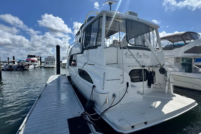 Slide: The Image of 2003 Silverton 43 Motor Yacht docked at marina under blue sky. - 6