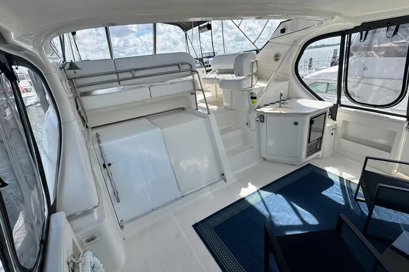 Slide: The Image of 2003 Silverton 43 Motor Yacht interior with seating, sink, and windows overlooking water. - 8