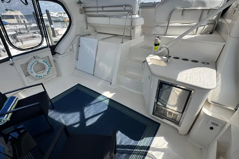 Slide: The Image of 2003 Silverton 43 Motor Yacht interior with seating, mini fridge, and nautical decor. - 9