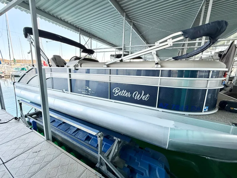 Slide: The Image of 2019 Bennington SX 25 Premium Swingback pontoon boat docked under a covered marina. - 2