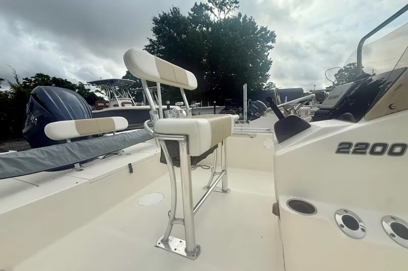 Slide: The Image of 2021 Bulls Bay 2200 boat interior with seating and console, under cloudy sky. - 3