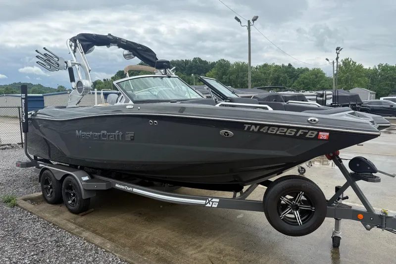 Slide: The Image of 2021 MasterCraft XT22 boat on trailer, sleek design, parked outdoors. - 1