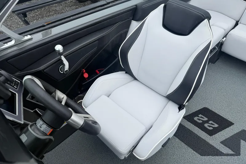 Slide: The Image of 2021 MasterCraft XT22 boat interior with sleek steering wheel and modern captain's seat. - 11
