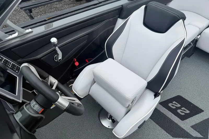 Slide: The Image of 2021 MasterCraft XT22 boat interior with sleek steering wheel and modern captain's chair. - 12
