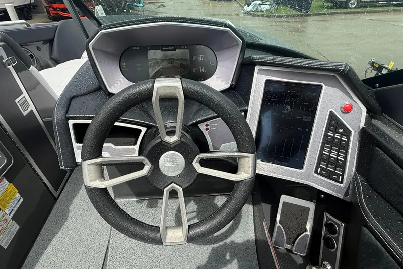 Slide: The Image of 2021 MasterCraft XT22 boat dashboard with steering wheel and digital display. - 13