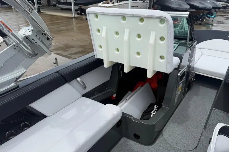 Slide: The Image of 2021 MasterCraft XT22 boat interior with open storage compartment and seating. - 23
