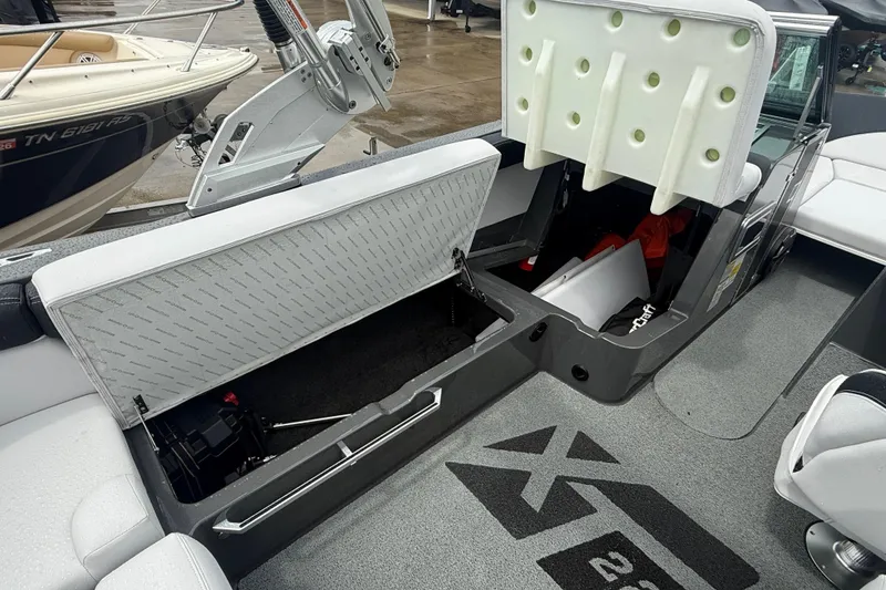 Slide: The Image of 2021 MasterCraft XT22 boat interior storage compartments open, showcasing spacious design. - 24