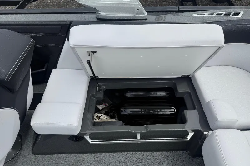 Slide: The Image of 2021 MasterCraft XT22 boat interior with open storage compartment under white seating. - 25