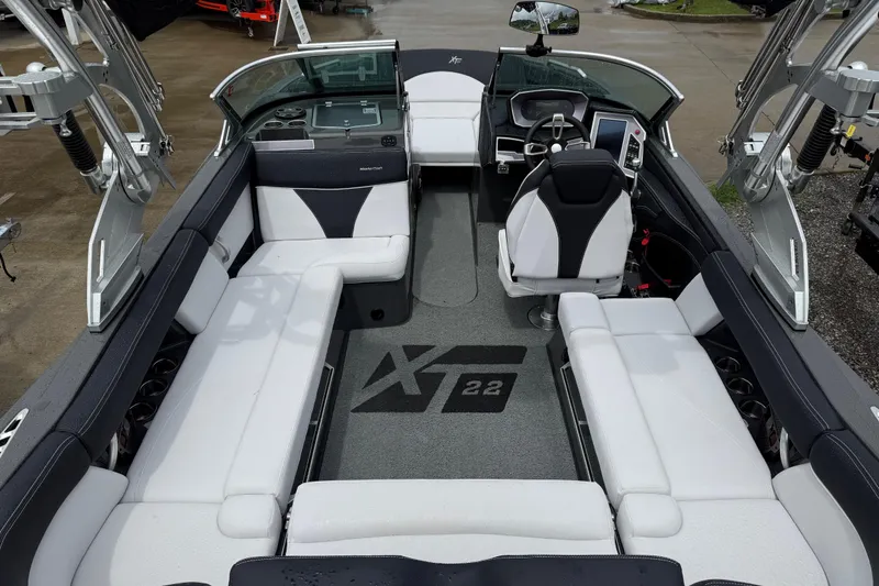 Slide: The Image of 2021 MasterCraft XT22 boat interior with white seating and modern dashboard. - 28