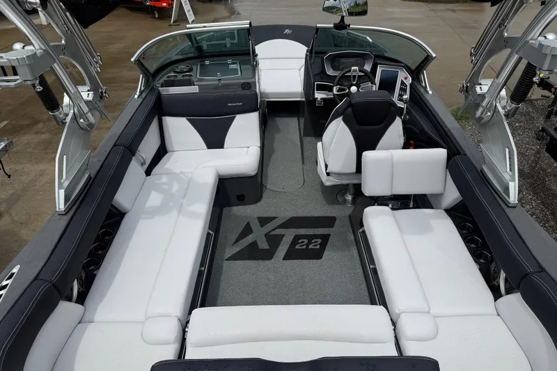 Slide: The Image of 2021 MasterCraft XT22 boat interior with white seating and modern dashboard. - 29