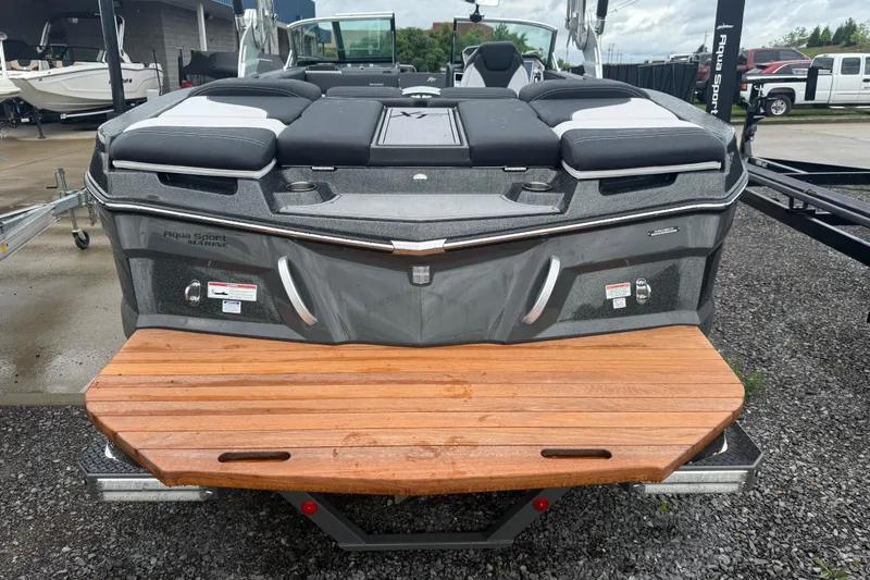 Slide: The Image of 2021 MasterCraft XT22 boat with wooden swim platform, parked outdoors. - 3